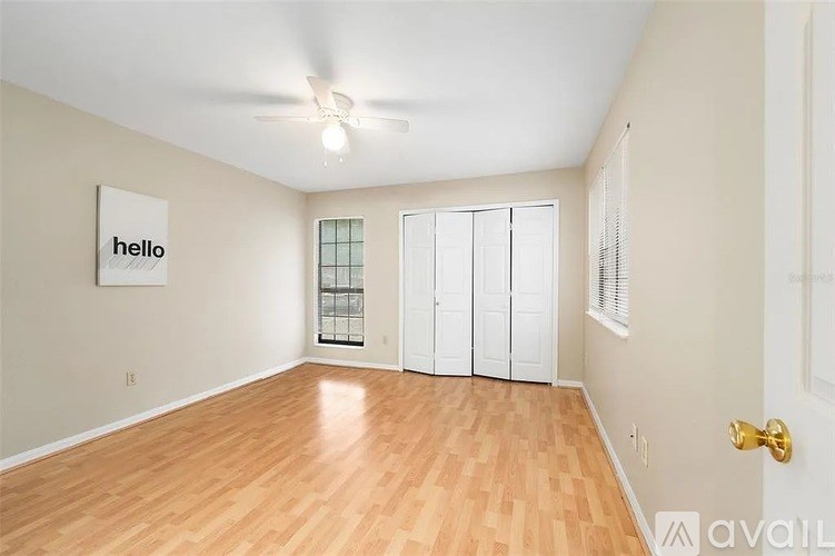 A room with wooden flooring and a ceiling fan.