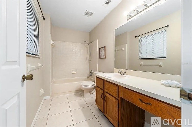 A bathroom with a toilet, sink, and mirror.