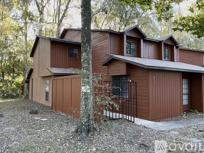 A brown house with a black iron fence in front of it.