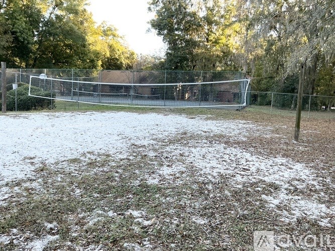 A soccer field covered in snow with a goal post visible.