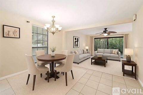 A well-lit living room with a dining table and chairs.