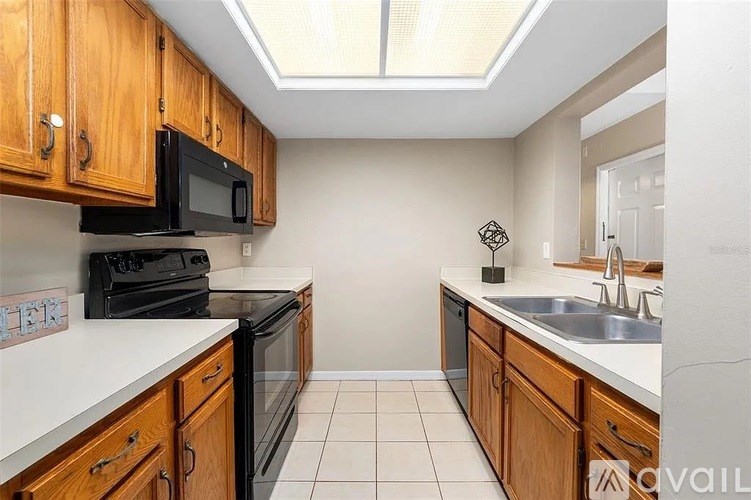 A kitchen with black appliances and wooden cabinets.