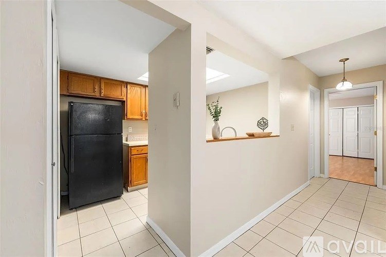 A kitchen with a black fridge and wooden cabinets.