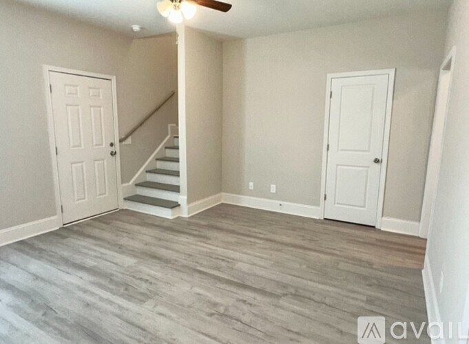 A room with a staircase and two doors.