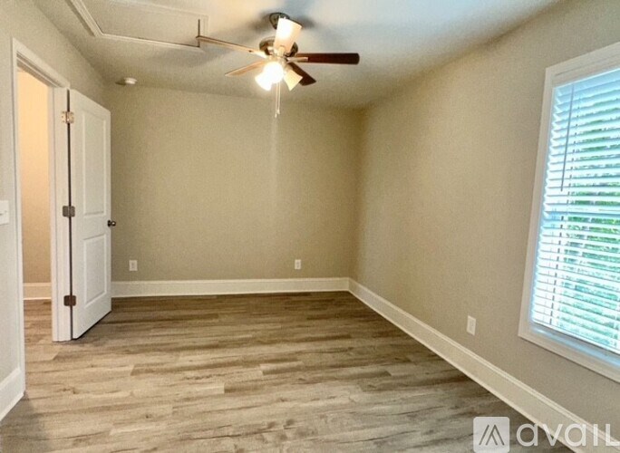 A room with a ceiling fan and a door.