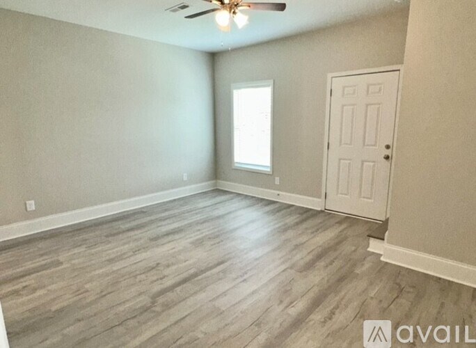 A room with a ceiling fan and a door.