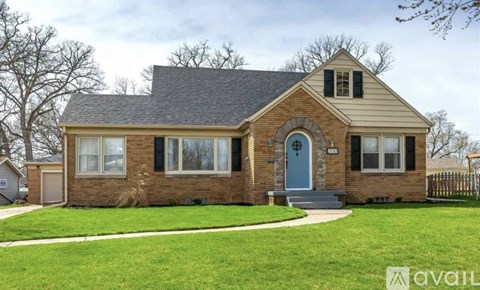 A house with a blue door and a brick exterior is for sale.