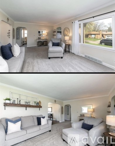 A living room with a grey couch and a white chair.