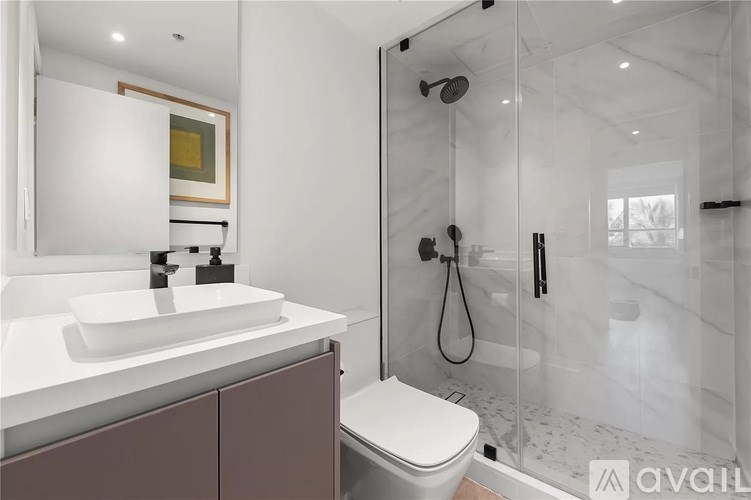 A bathroom with a white sink and a walk-in shower.