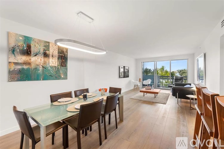 A modern dining room with a glass table and chairs.