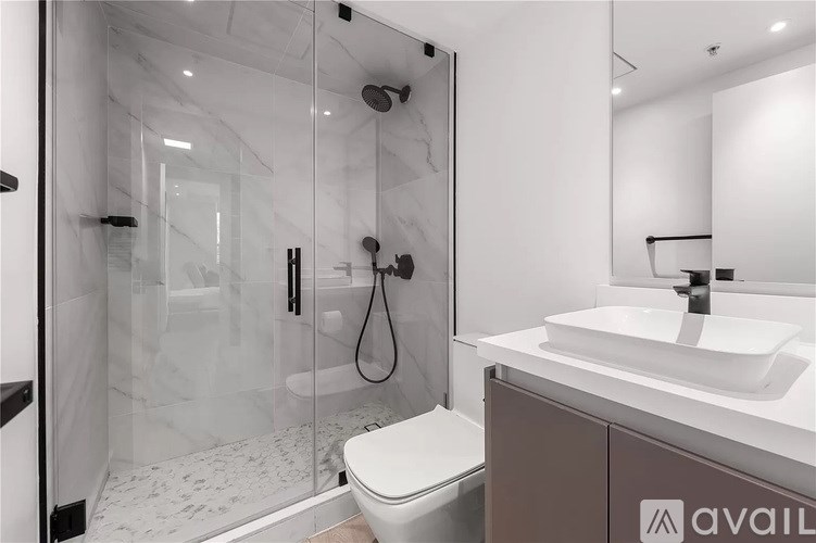 A bathroom with a toilet, sink, and shower.