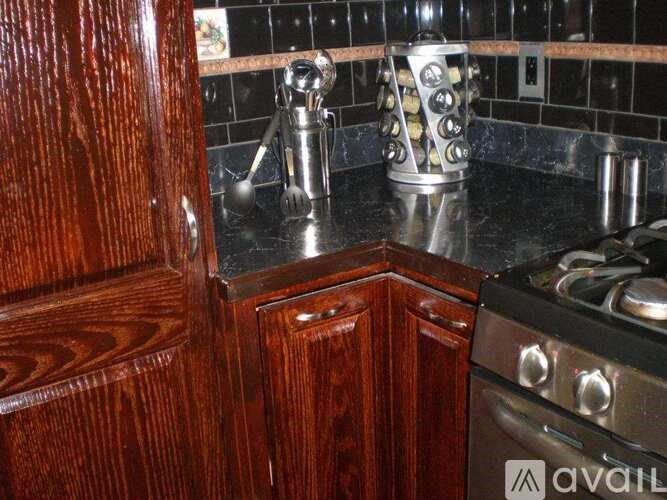 A kitchen with a wooden cabinet and a stove top oven.