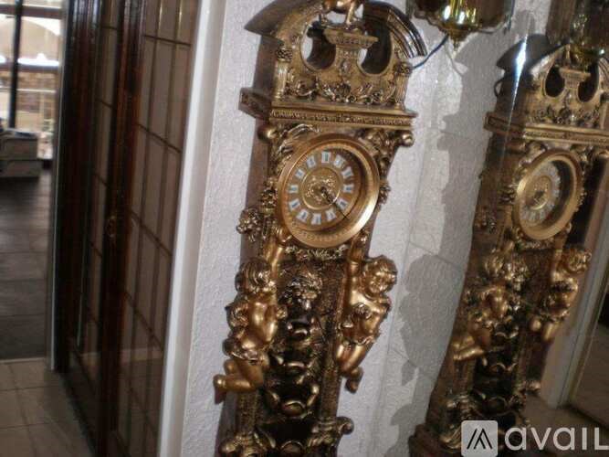 A large ornate gold clock is mounted on a wall.