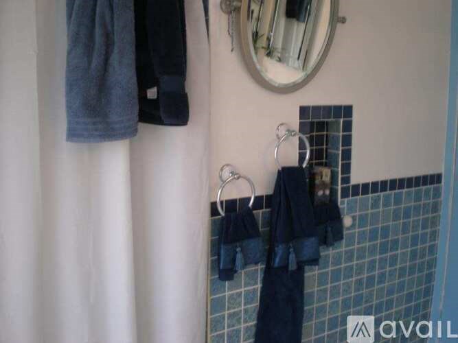 A bathroom with a mirror, towel rack, and towels.