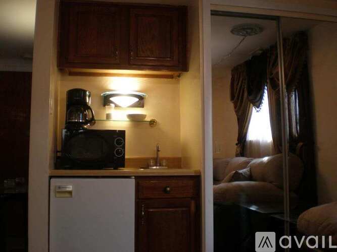 A small kitchen with a refrigerator, microwave, and coffee maker.