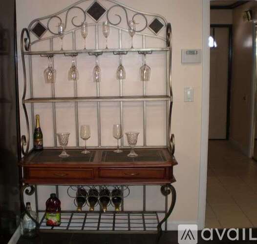 A metal wine rack with glasses and bottles on it.