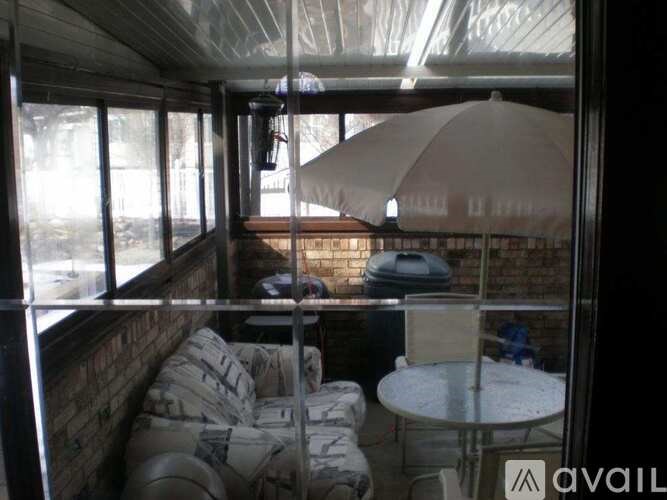A patio with a table and chairs under a white umbrella.