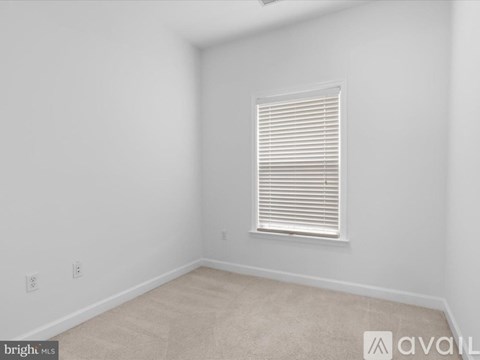 A room with a window and carpeted floor.