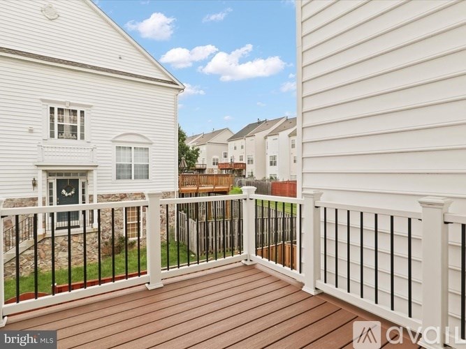A balcony with a white railing and a wooden floor.