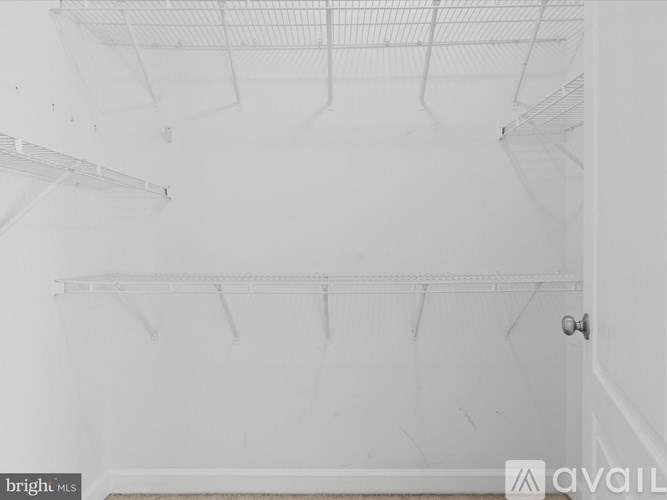 Empty white refrigerator with a door and shelves.