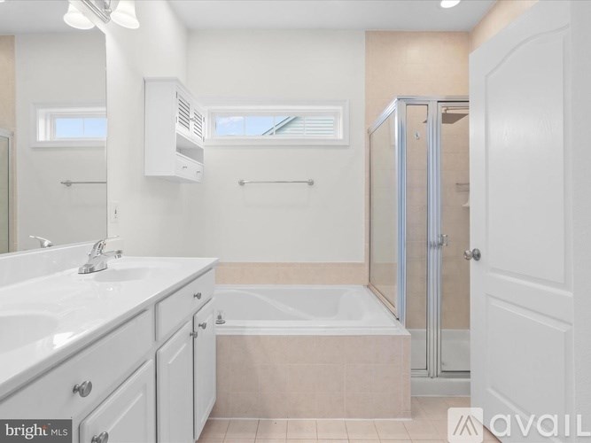 A bathroom with a tub, sink, and shower.