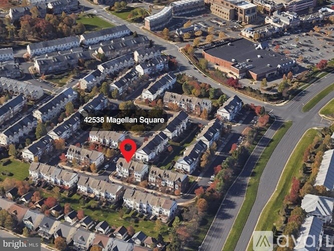 An aerial view of a residential area with a red marker indicating a specific location.