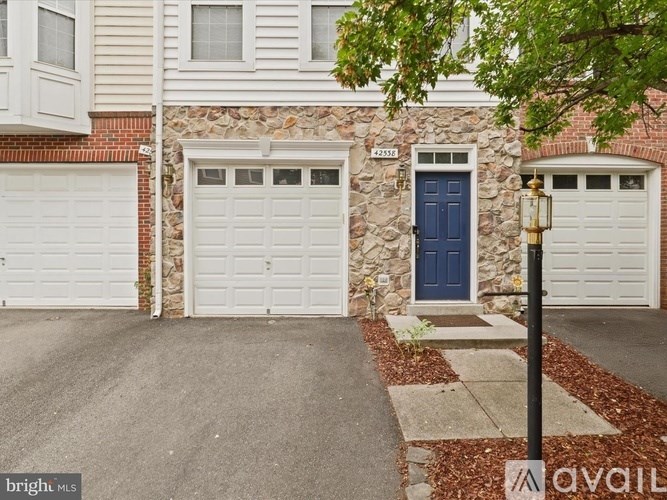 A house with a blue door and white garage doors.