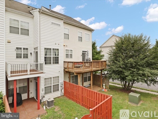 A two-story apartment building with a balcony and a deck.
