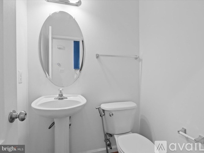 A white bathroom with a sink, toilet and mirror.