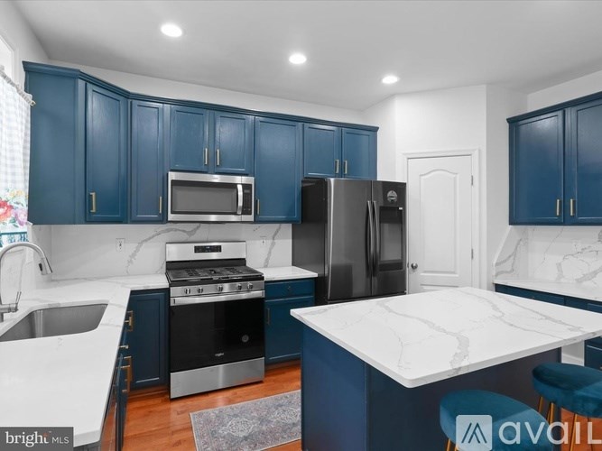 A kitchen with blue cabinets and a white island.