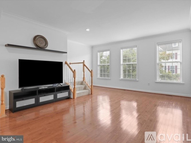 A living room with a television, a staircase, and a fireplace.