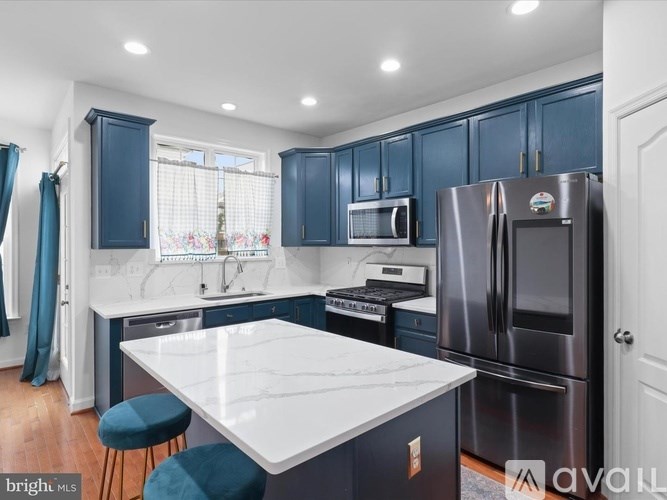 A kitchen with dark blue cabinets and a white countertop.