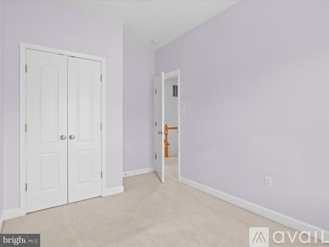 A room with two white doors and a carpeted floor.
