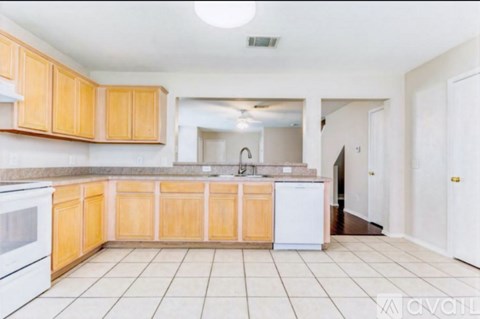 A kitchen with wooden cabinets and a white dishwasher.
