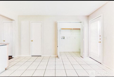 A white tiled room with four doors.