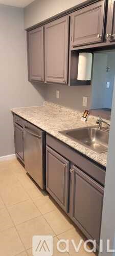 A kitchen with brown cabinets and a granite countertop.