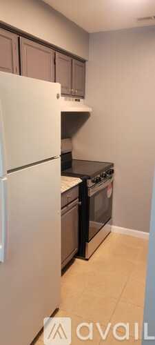 A kitchen with a white refrigerator and black countertops.