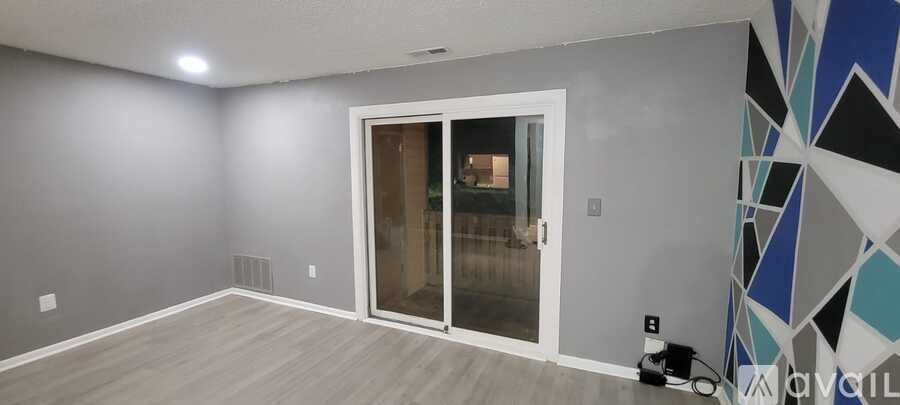 A room with a grey wall and a white door.