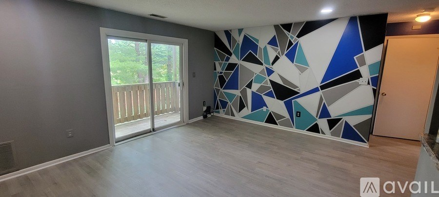 A room with a wall covered in blue and white triangles and a sliding glass door.