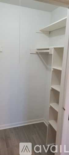 A white closet with shelves and a door.