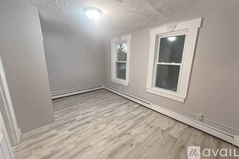 A room with a window and wooden flooring.