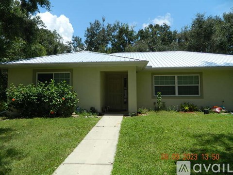 A house with a green lawn and a white metal roof.