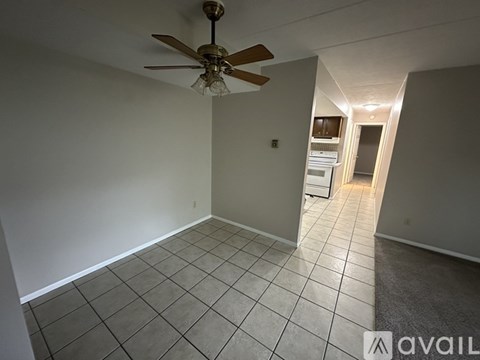 A room with a ceiling fan and tiled flooring.