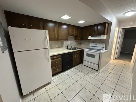 A kitchen with white appliances and brown cabinets.