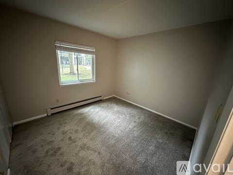 Empty room with a window and carpeted floor.