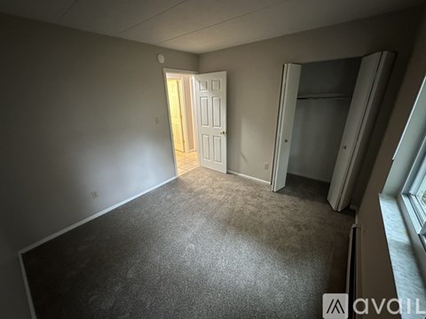 A room with a carpeted floor and a doorway leading to another room.
