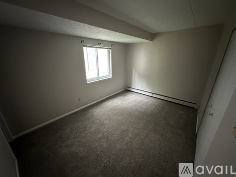 A room with a window and carpeted floor.