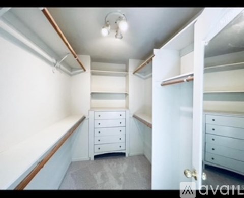 A bedroom with a bed, dresser, and a small closet.