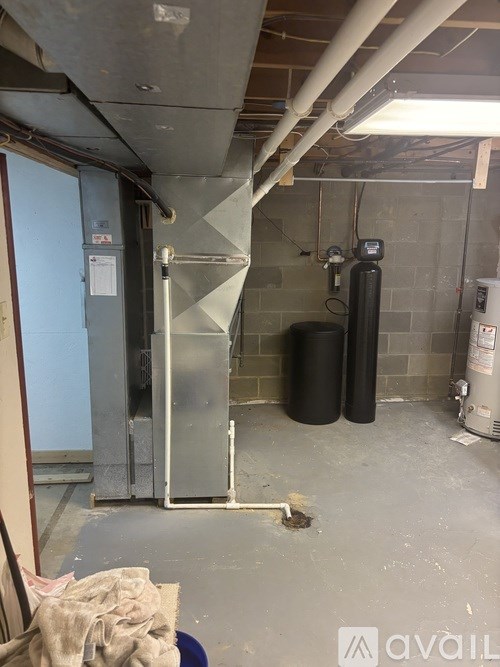 A room with a water heater and a tank.