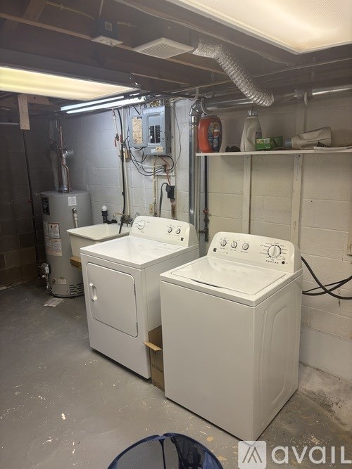 Two white washing machines in a laundry room.